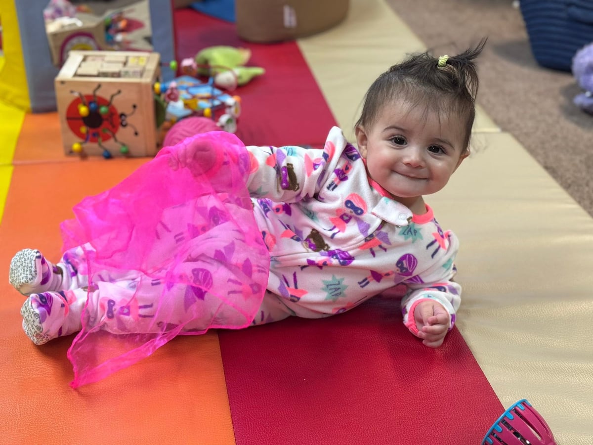 Infant enjoying supervised floor play while developing balance, coordination, and confidence through movement at Primrose School.