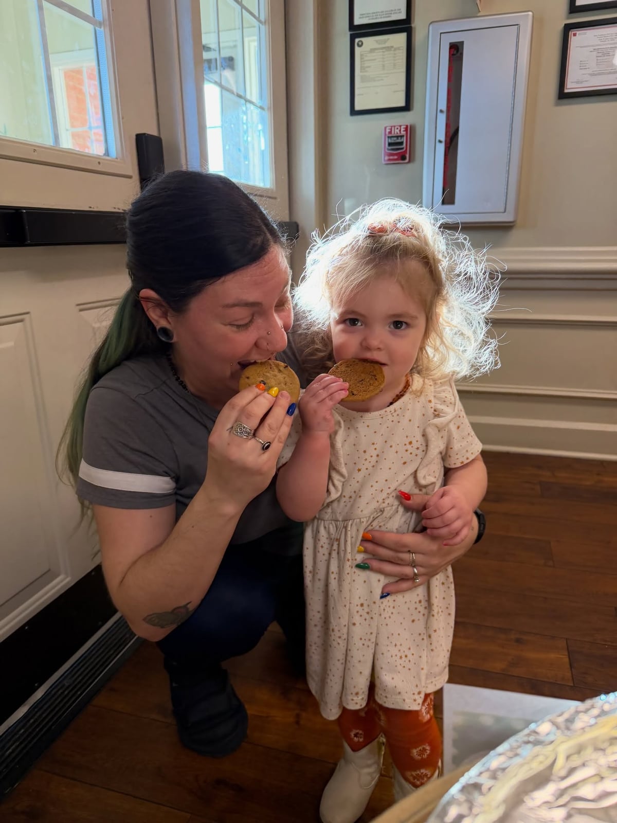 Student and teacher eating a cookie on cookie Friday