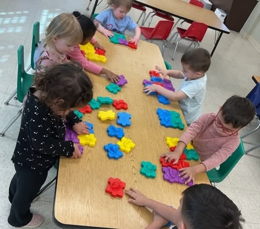 Preschoolers working together on a puzzle