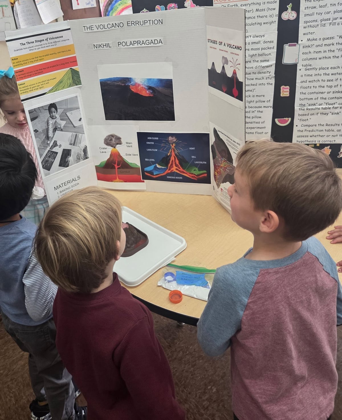 Pre-K students gathered around a volcano science display while learning about volcanic eruptions through a hands-on STEM project that encourages curiosity, observation, and scientific thinking at Primrose School.