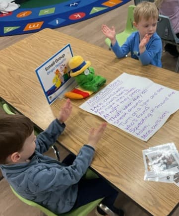 2 boys clapping out syllables during literacy small group