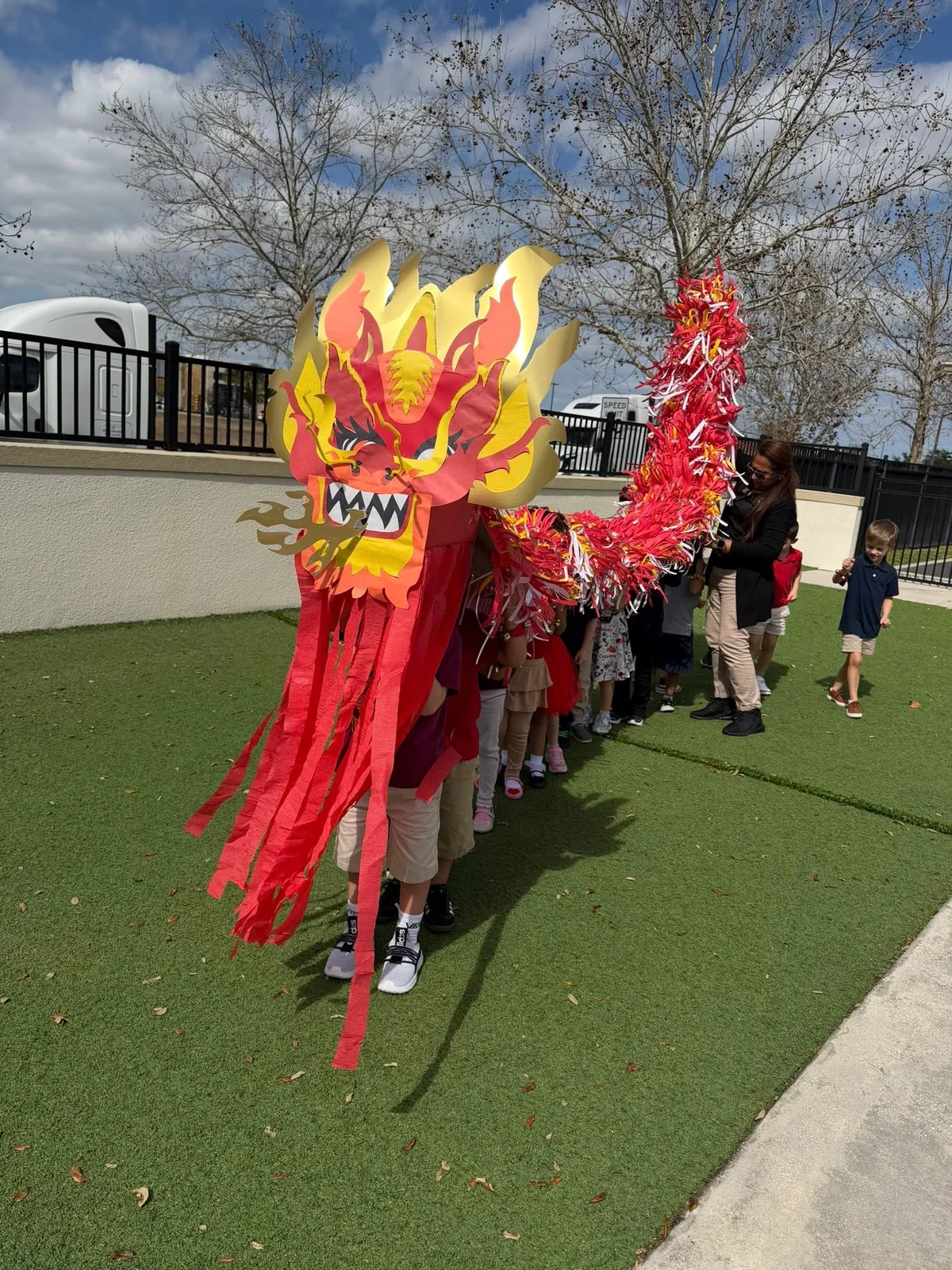 Red and yellow dragon with children underneath it