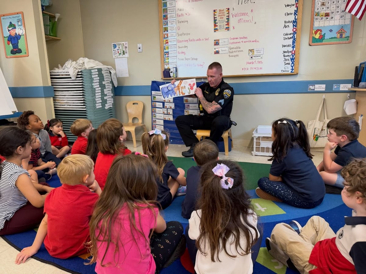 police officer reaching to kindergarteners during circle time