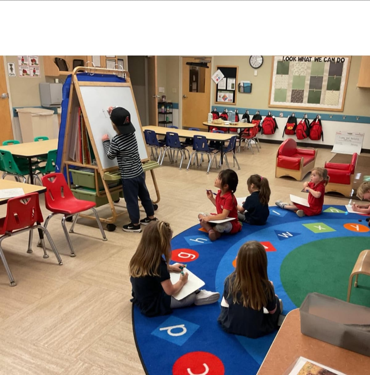 Preschool students sit together during an interactive classroom lesson, practicing early writing and listening skills at Primrose School.