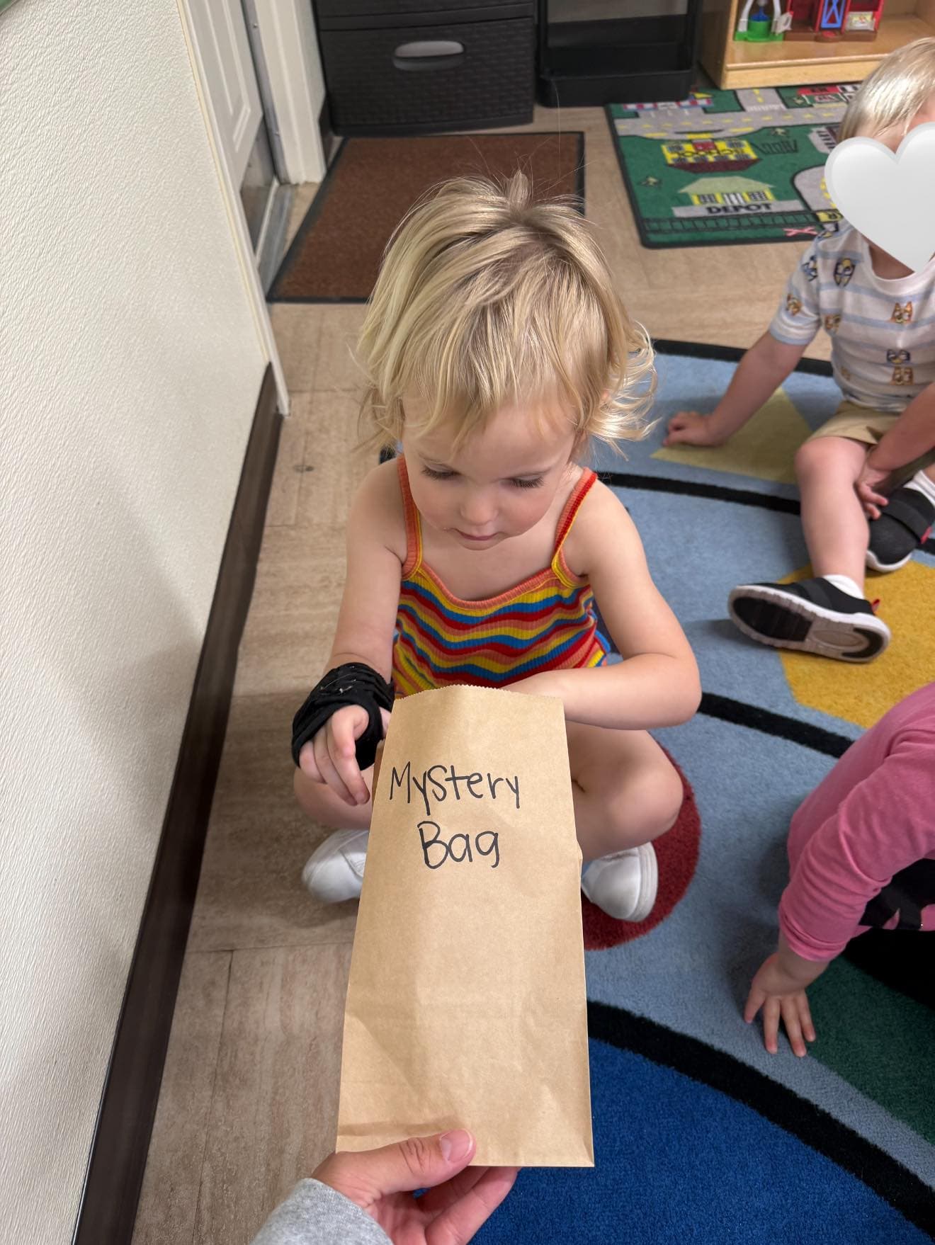 Preschool student participating in a sensory mystery bag activity that encourages observation and critical thinking.