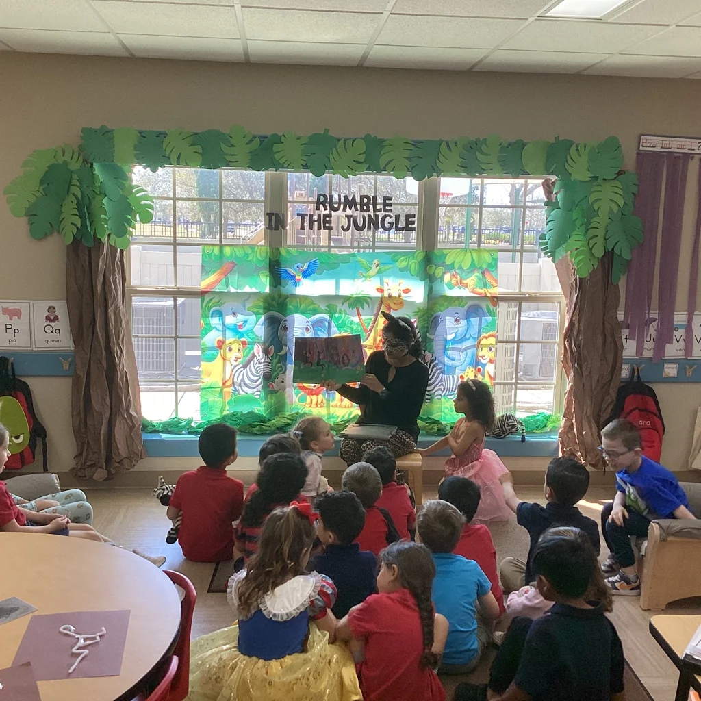 children sitting in front of a teacher reading a story about the jungle