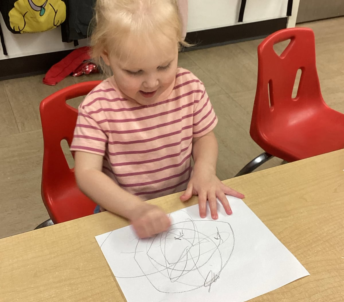 Preschooler drawing on paper during a classroom art activity that encourages self-expression, creativity, and early writing skills at Primrose School.