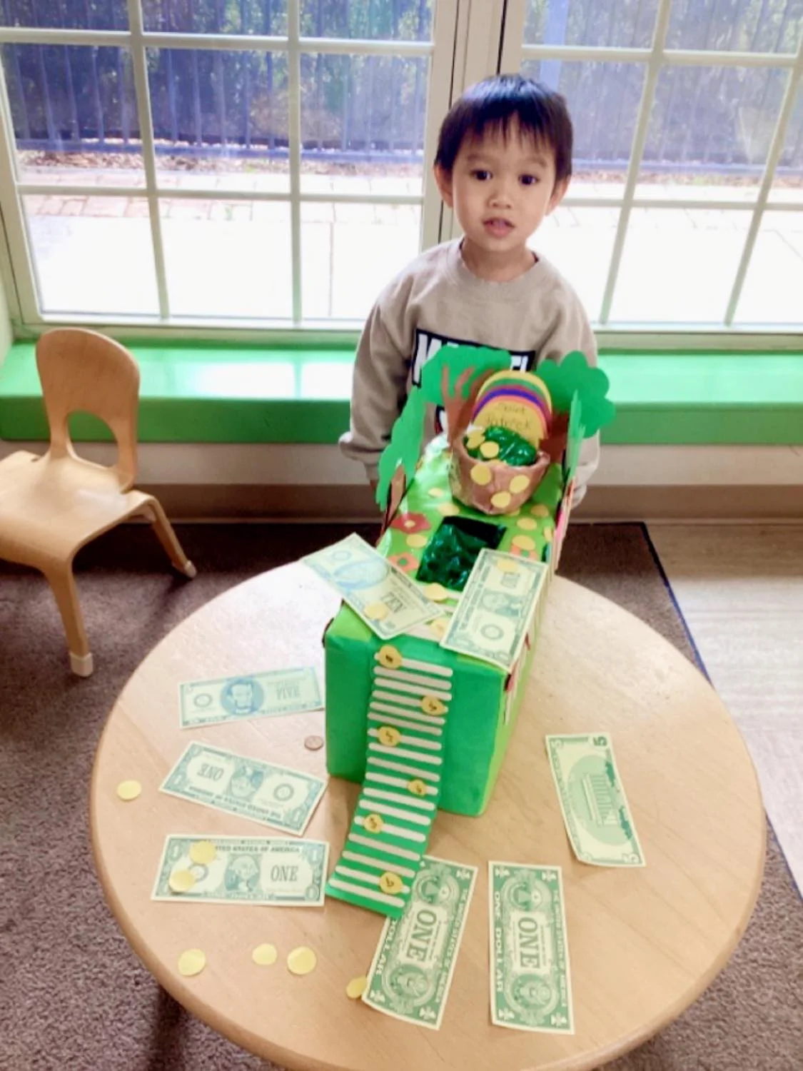 boy wearing green standing in front of a leprechaun trap