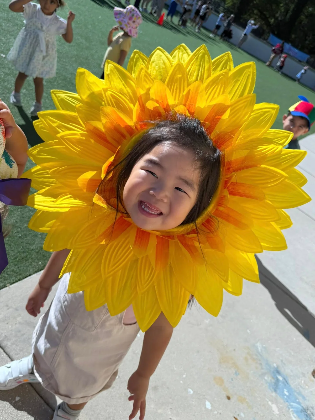 girl wearing sunflower hat outside