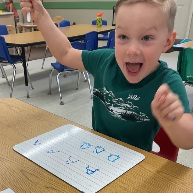 Pre-K student practicing letter formation and early handwriting skills while strengthening pencil grip, fine motor development, and school readiness at Primrose School.