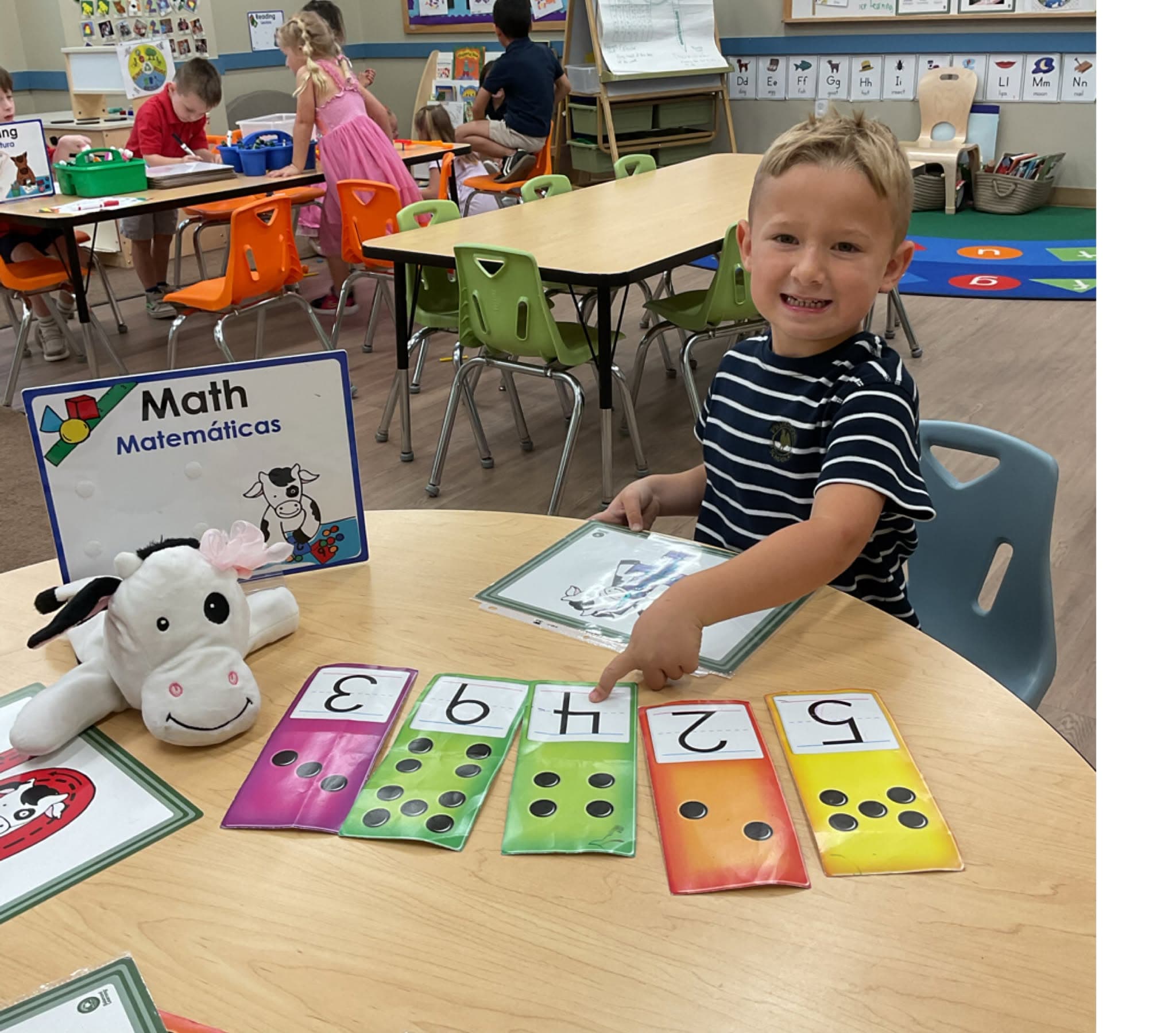 Student matching numbers and quantities during a hands-on math activity designed to build number recognition, counting, and early problem-solving skills.