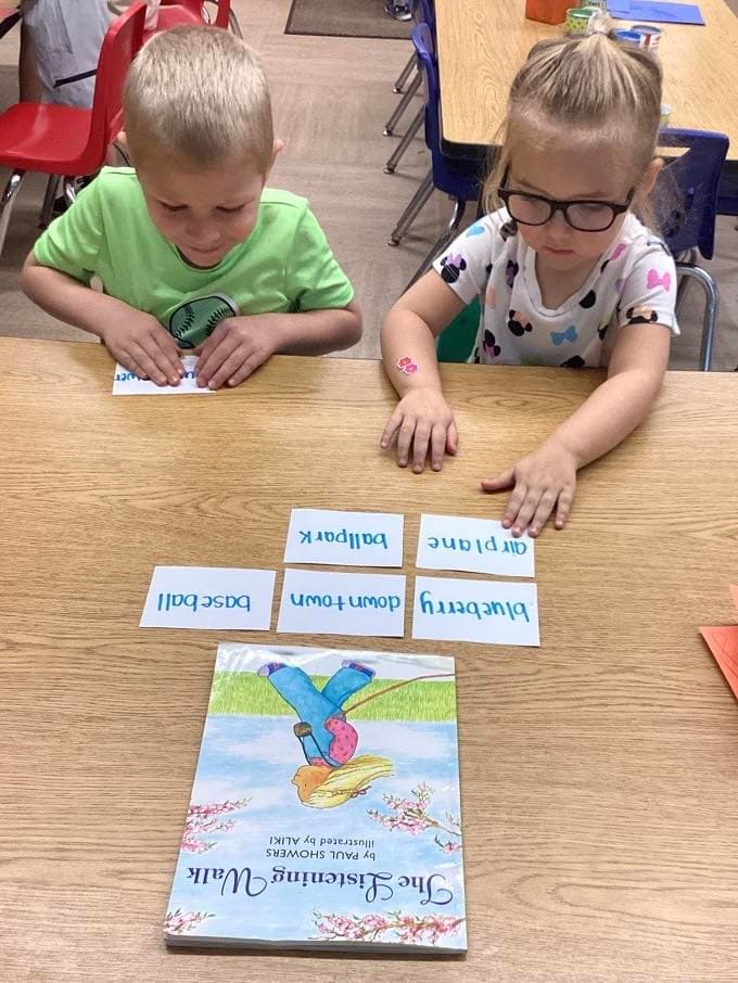 Preschool students practicing literacy and word matching skills during a small-group reading activity inspired by a classroom story.