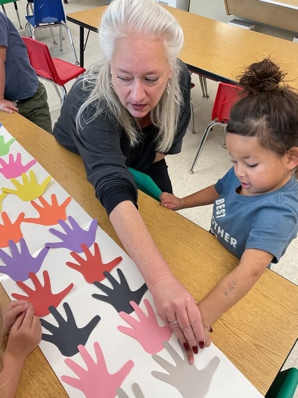 Preschool student working with a teacher to identify colors and patterns while strengthening observation skills, critical thinking, and confidence through interactive learning at Primrose School.