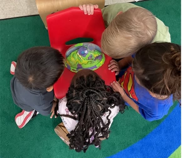 Preschool students collaborating to observe a hands-on science activity, building curiosity, teamwork, problem-solving, and STEM exploration at Primrose School.