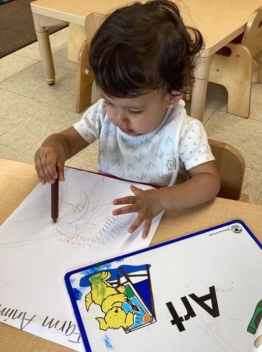 Young child practicing early writing and drawing skills at Primrose School, developing fine motor skills, creativity, and kindergarten readiness through hands-on learning activities.