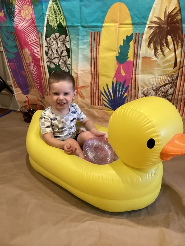 boy sitting on blow up rubber duck