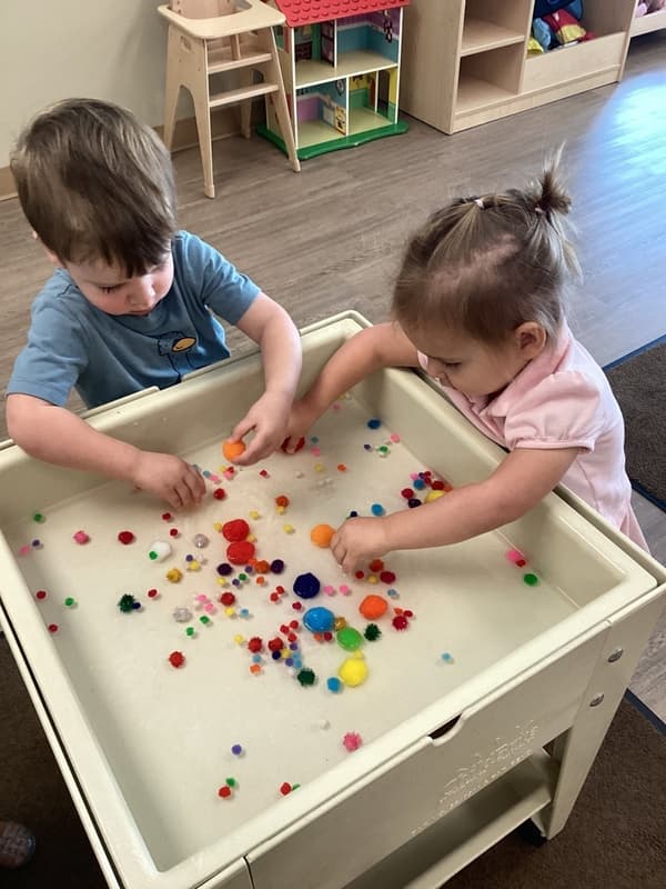 children using pompoms in the water