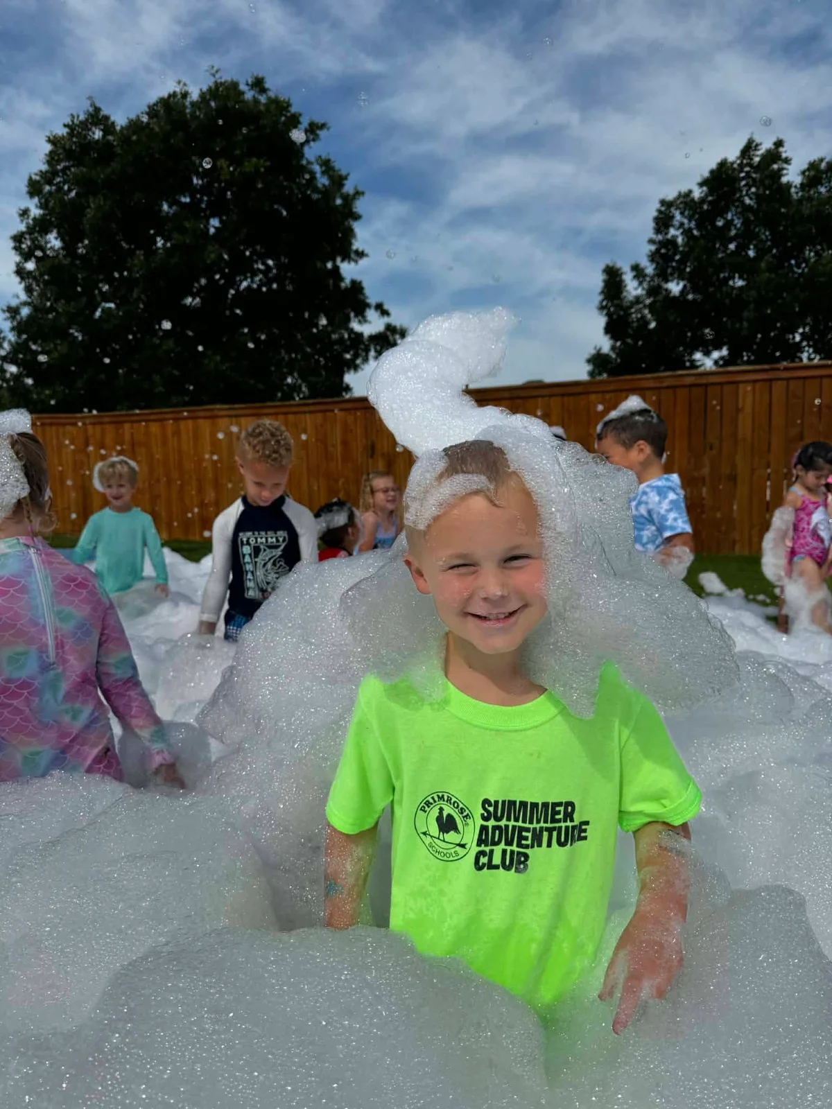 A pre-kindergarten student participating in a foam party at Primrose School at Heritage.