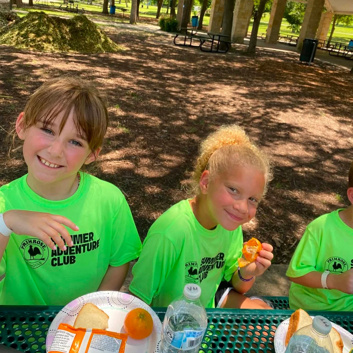 Summer Adventure Club students eating lunch in the park on a field trip with Primrose School at Heritage.