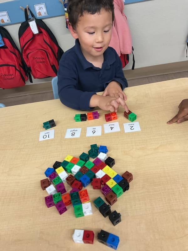 child is counting by two's using cubes