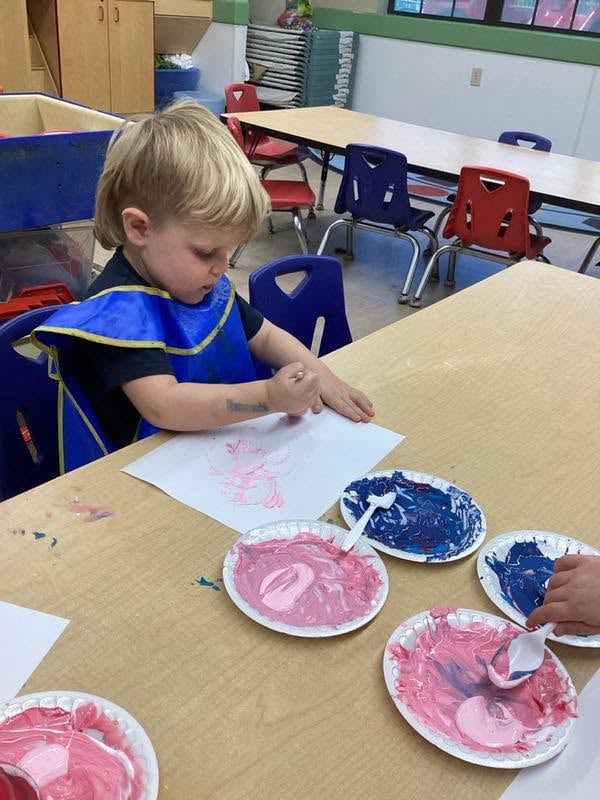 Preschooler creating artwork with finger paint during a sensory-rich classroom activity that encourages creativity, self-expression, and fine motor development at Primrose School.