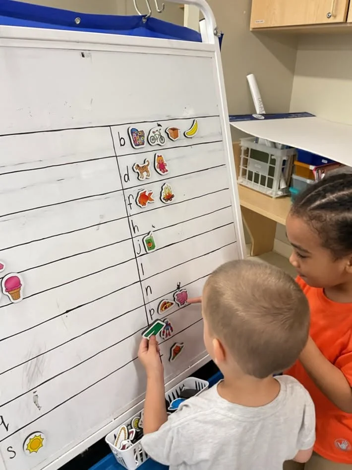 preschoolers working together on a board activity