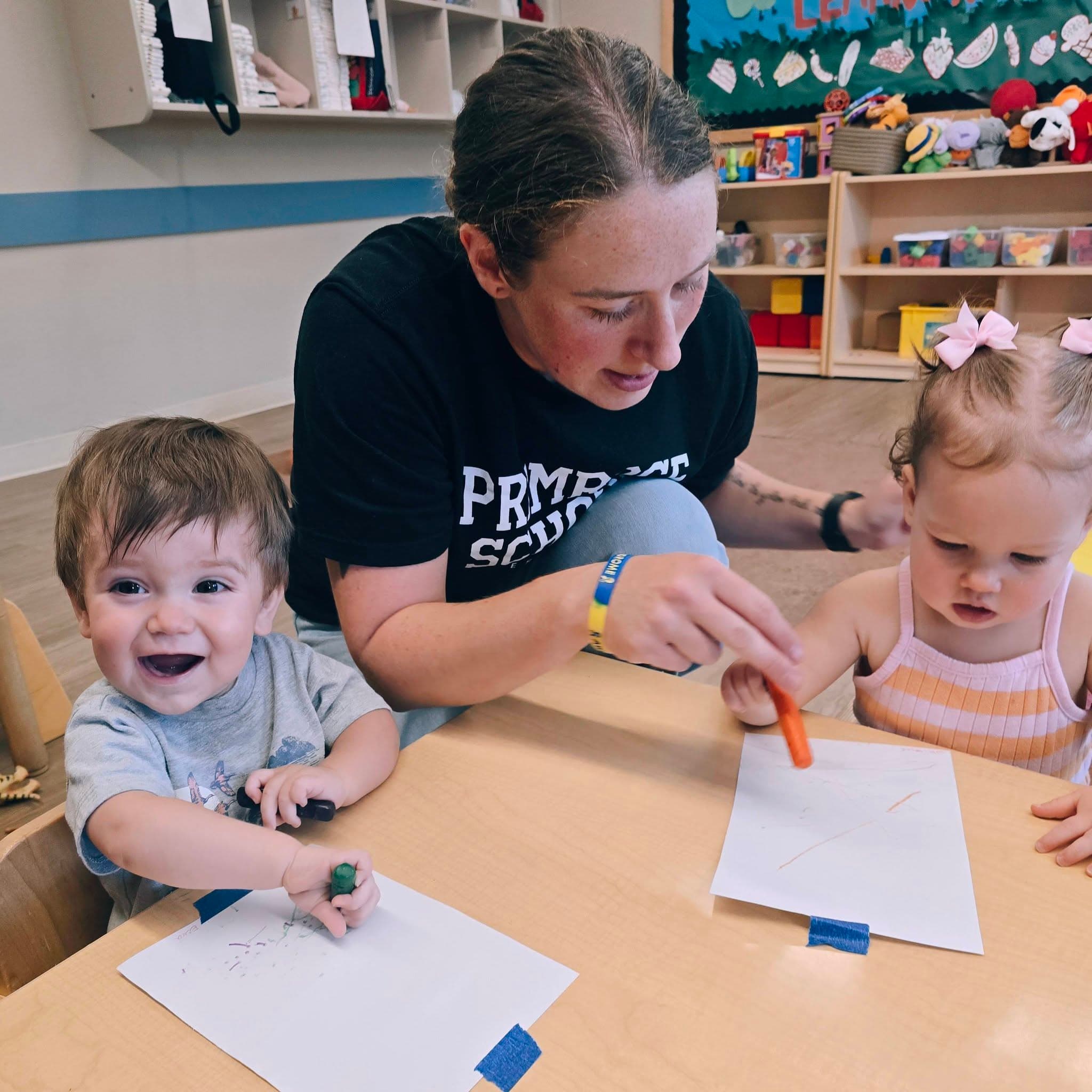 A toddler teacher engages with children in a small group at Primrose School at Heritage in Keller, TX