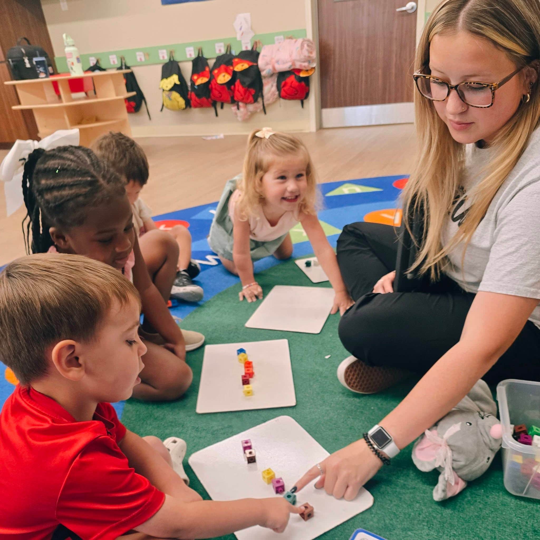A Preschool teacher leading her students in a small group lesson at Primrose School at Heritage in Keller, TX.