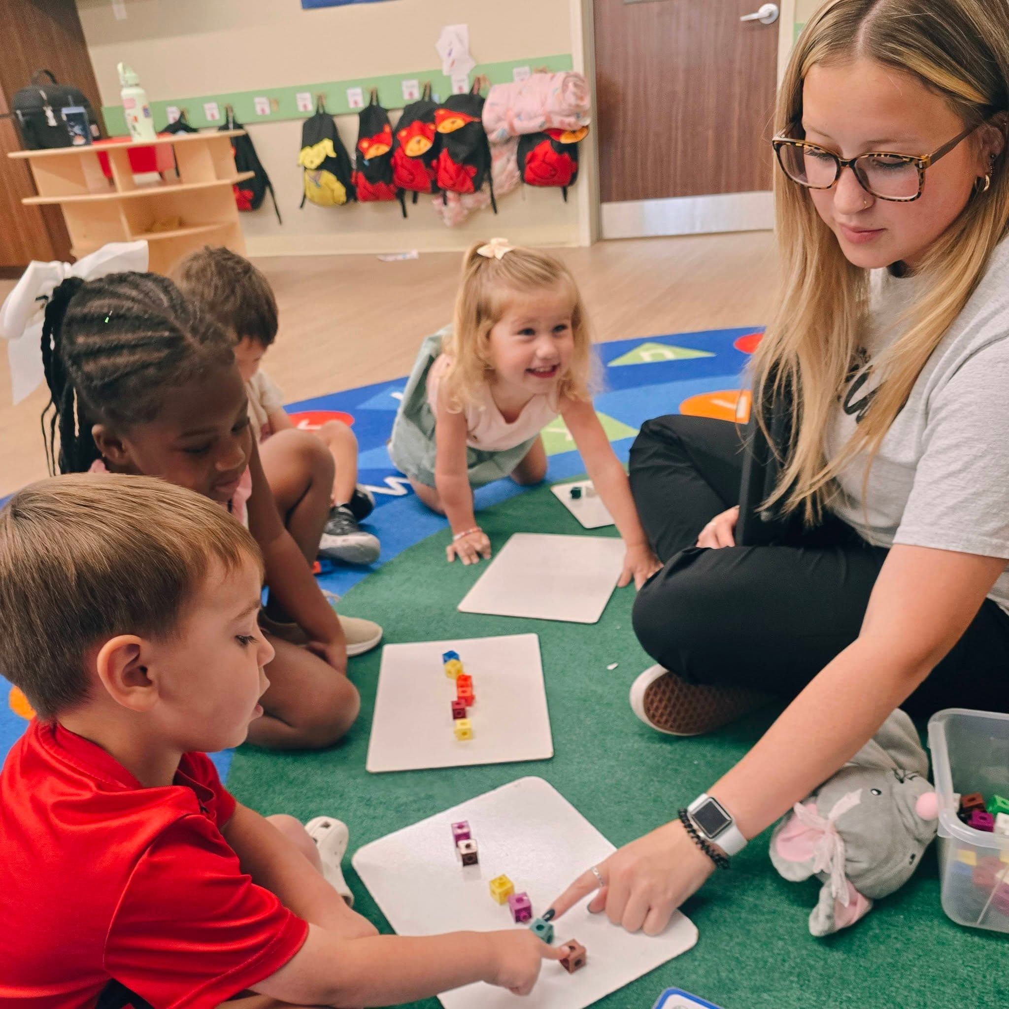 A Preschool teacher leading her students in a small group lesson at Primrose School at Heritage in Keller, TX.