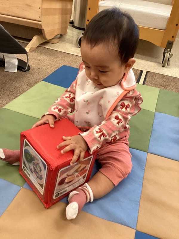 Infant exploring hands-on learning materials at Primrose School, encouraging curiosity, problem-solving, and early childhood development.