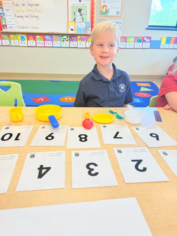 child at small group math counting house hold objects