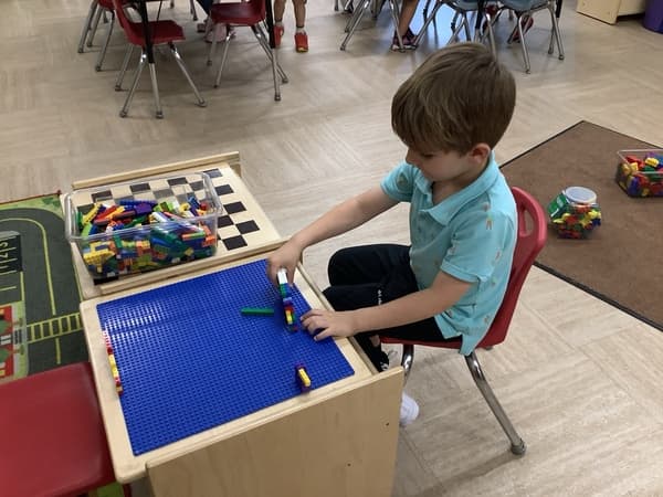 Child sitting down with legos