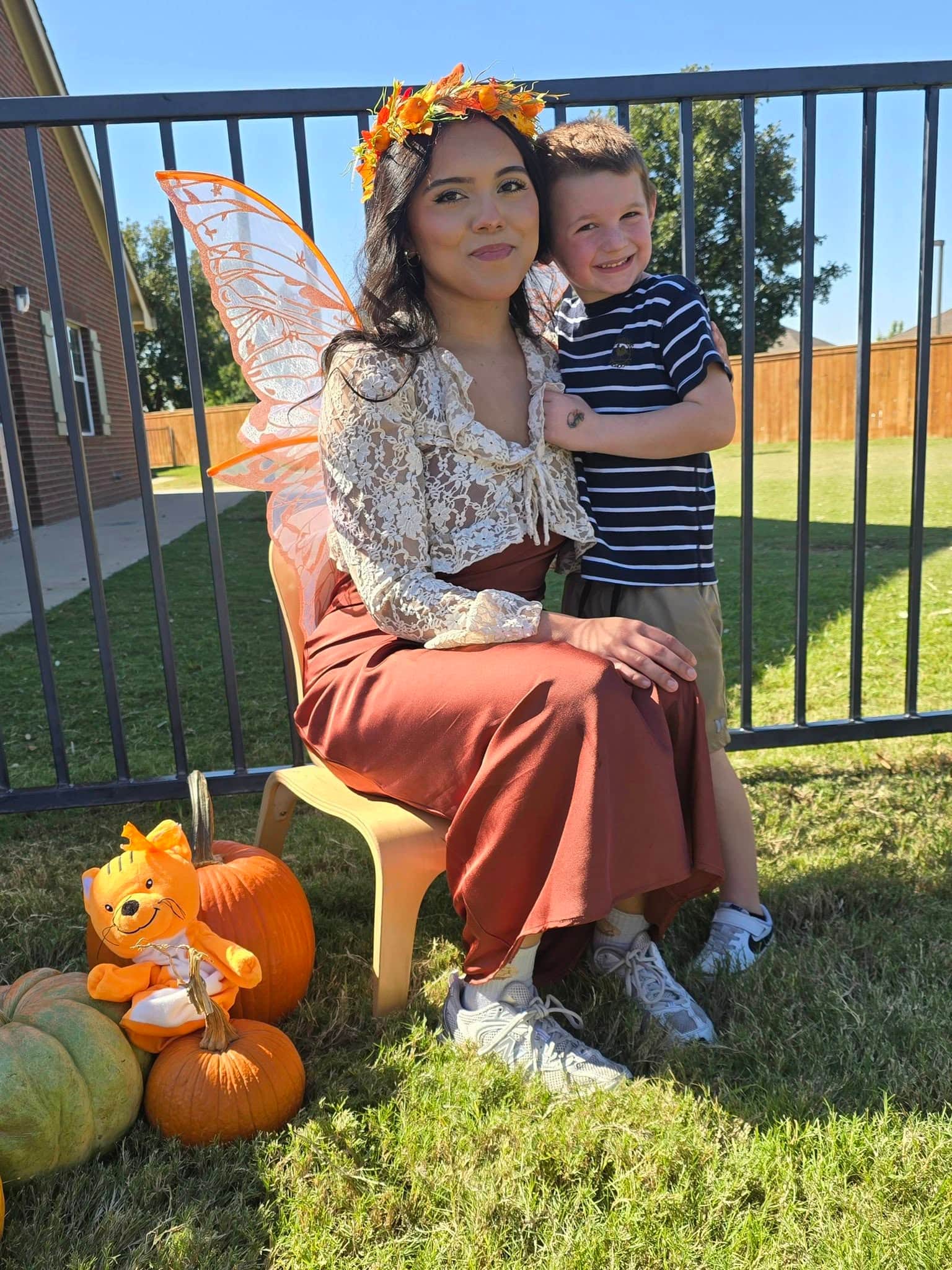 Pumpkin Fairy posing with a student wearing a Primrose uniform at Primrose School at Heritage, a preschool and daycare in Keller, TX, celebrating fall with a fun autumn-themed school activity.