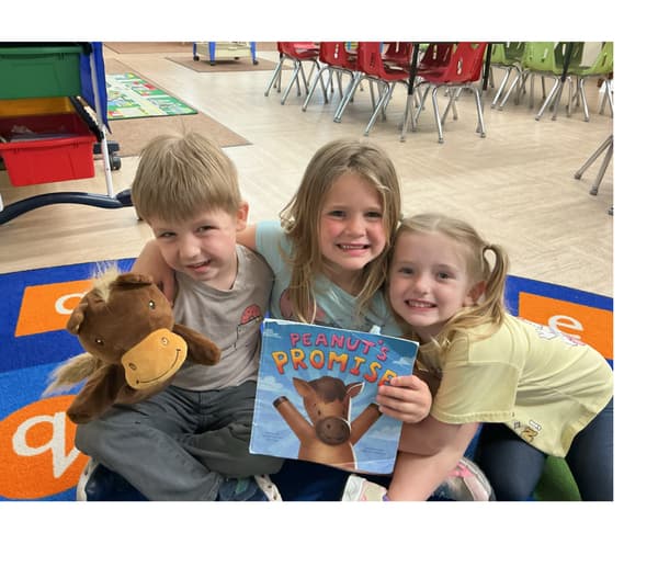 Children building friendships during story time at Alliance school.
