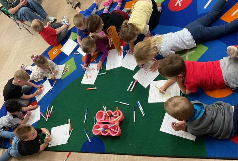 Group of children coloring on the floor