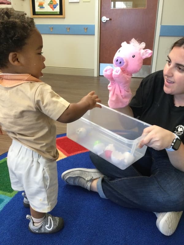 Primrose Fort Worth toddler teacher using a puppet to support language development during sensory activity with young toddlers at the best preschool, Bonds Ranch rd, Berkshire Elementary