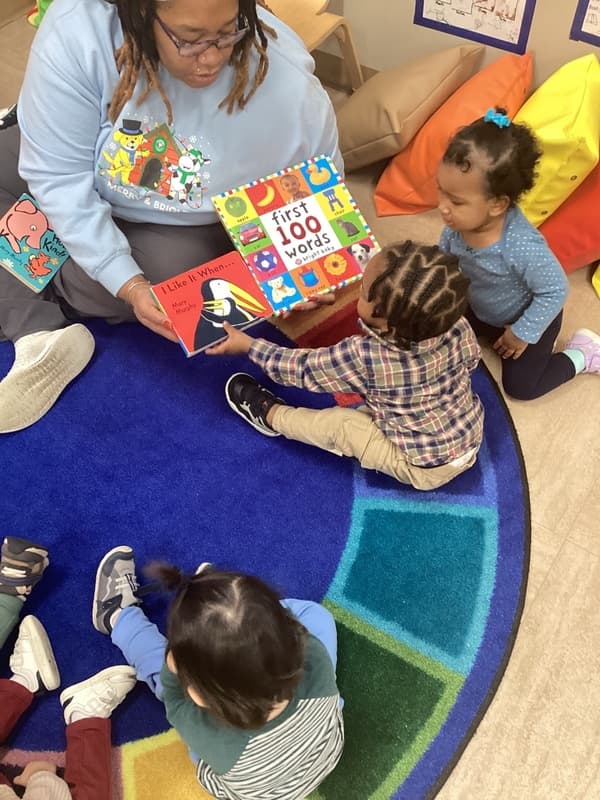 children pointing at book