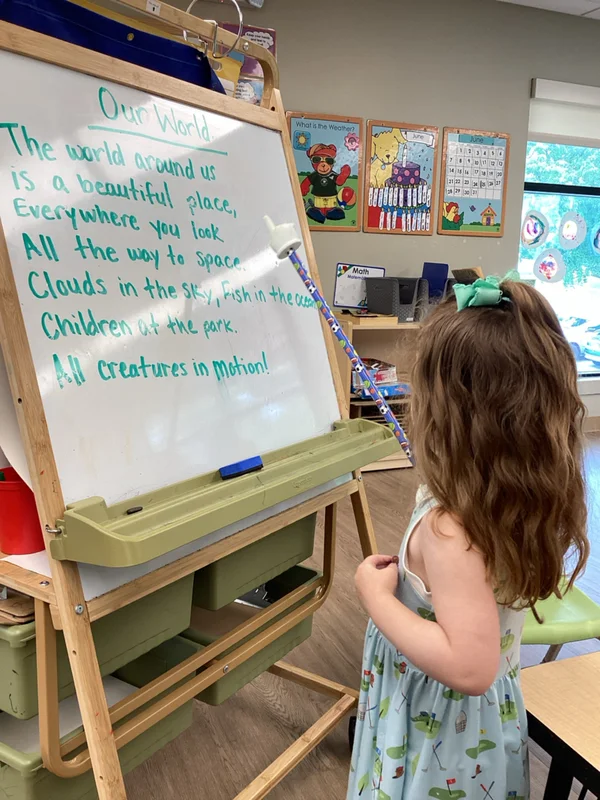 child using pointer at board
