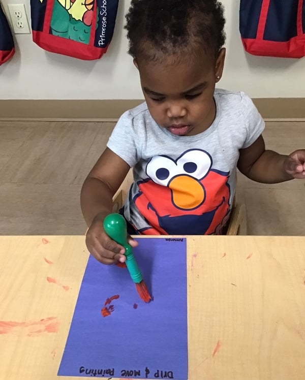 Toddler practicing fine motor skills by painting