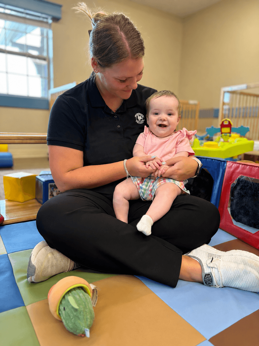 infant teacher loving on baby at Primrose School at Falling Waters