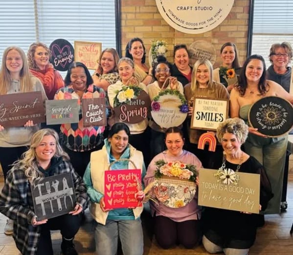 teachers at a group outing holding their artwork and smiling