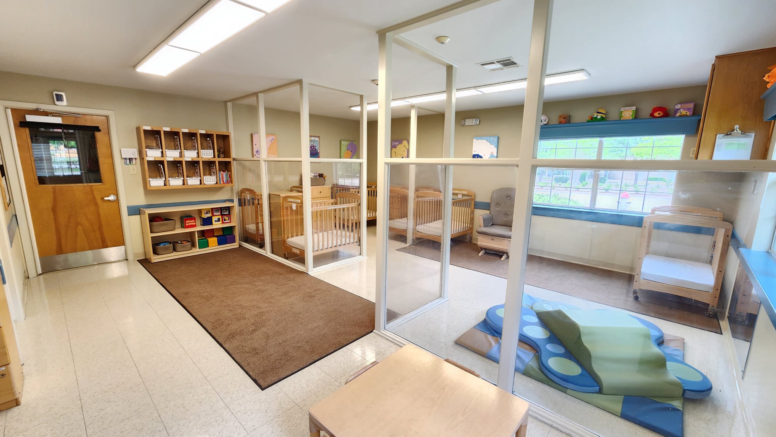 "Older Infants Room with Safe Baby Cribs, Colorful Play Equipment, and Stimulating Early Childhood Development Activities"