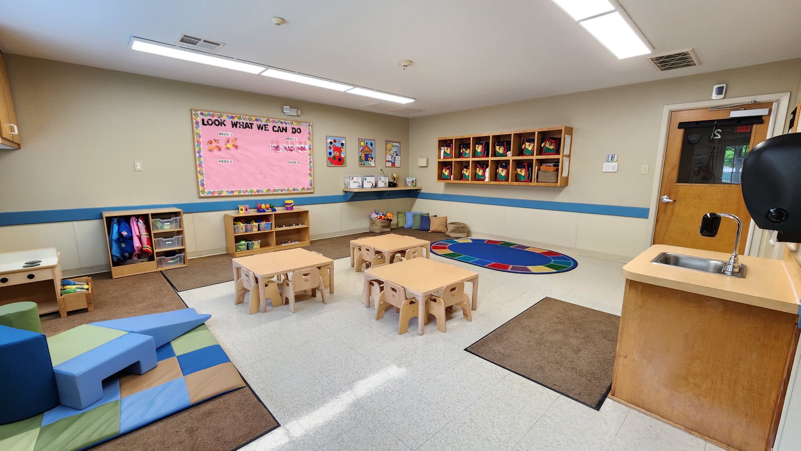 "Young Toddler Classroom, Neatly arranged safe tables and chairs, Colorful Play Equipment, and Stimulating Early Childhood Development Activities"