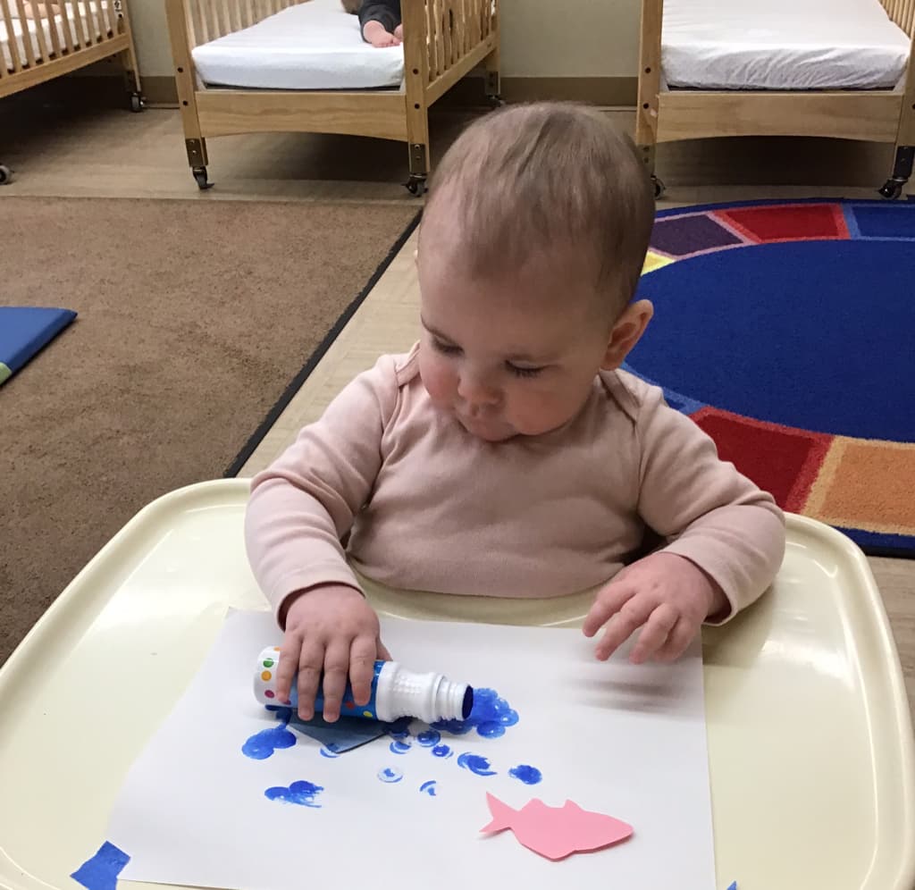 An infant doing artwork.