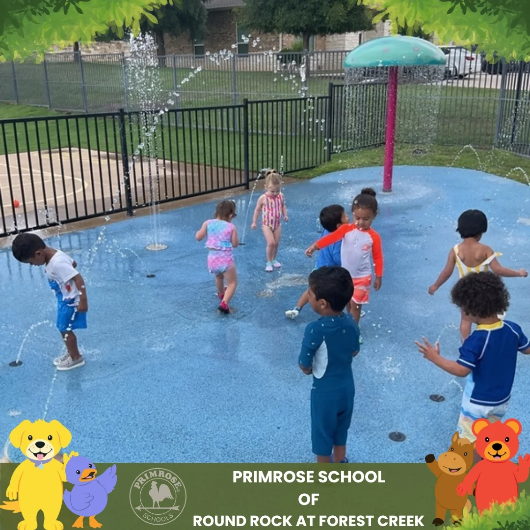 Children enjoying Splash Day at Primrose School of Round Rock at Forest Creek, playing in the outdoor splash pad during summer activities.