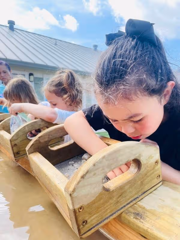 group of pre-kindergarten kids mining for gems and crystals during the fun and educational STEM summer program.