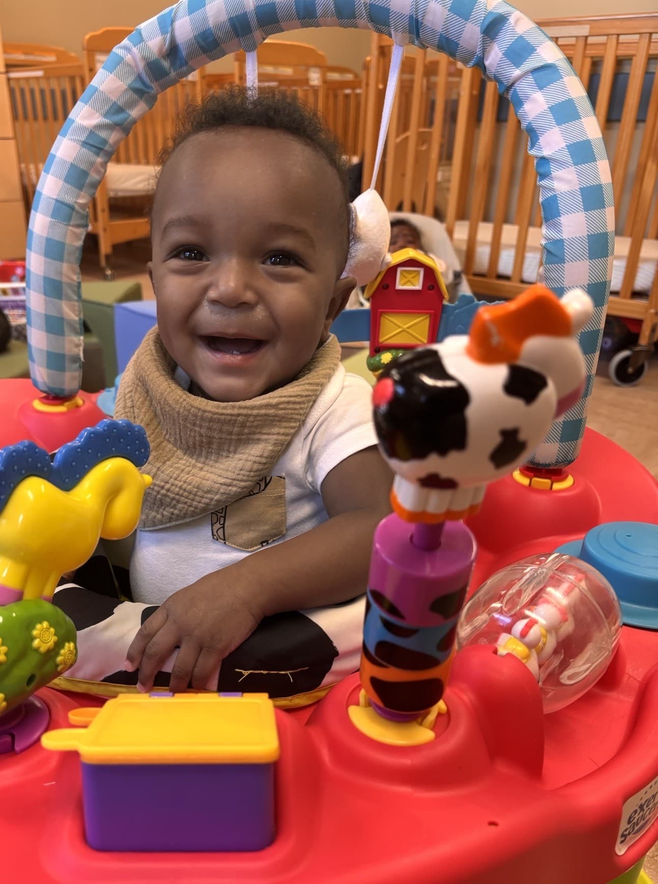 Joyful infant at Primrose School at Summerwood is playing in a bouncer