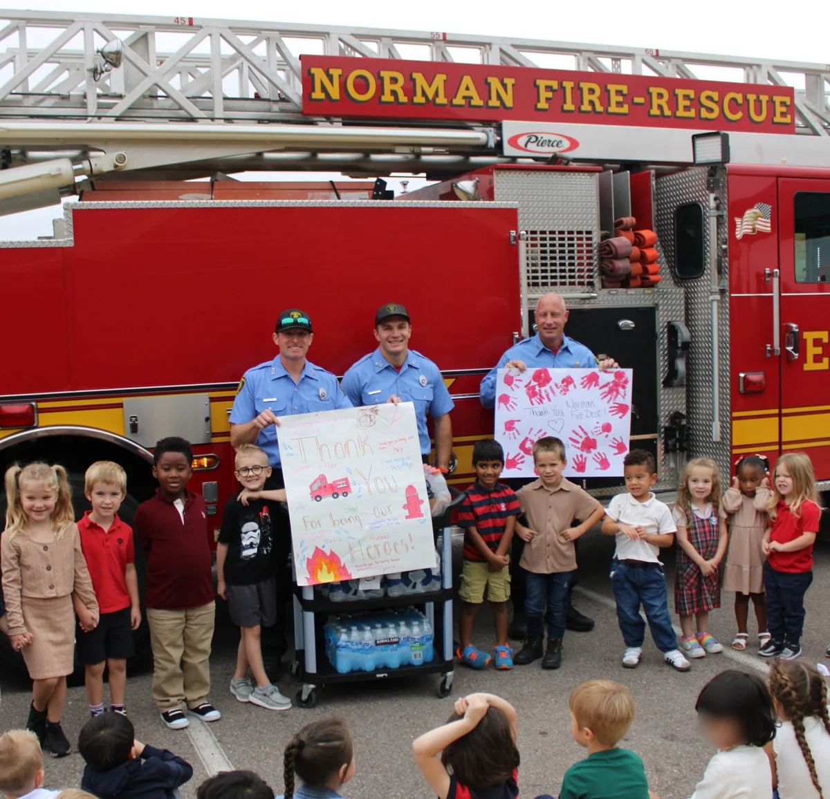 Children presenting firefighters with water and Gatorade