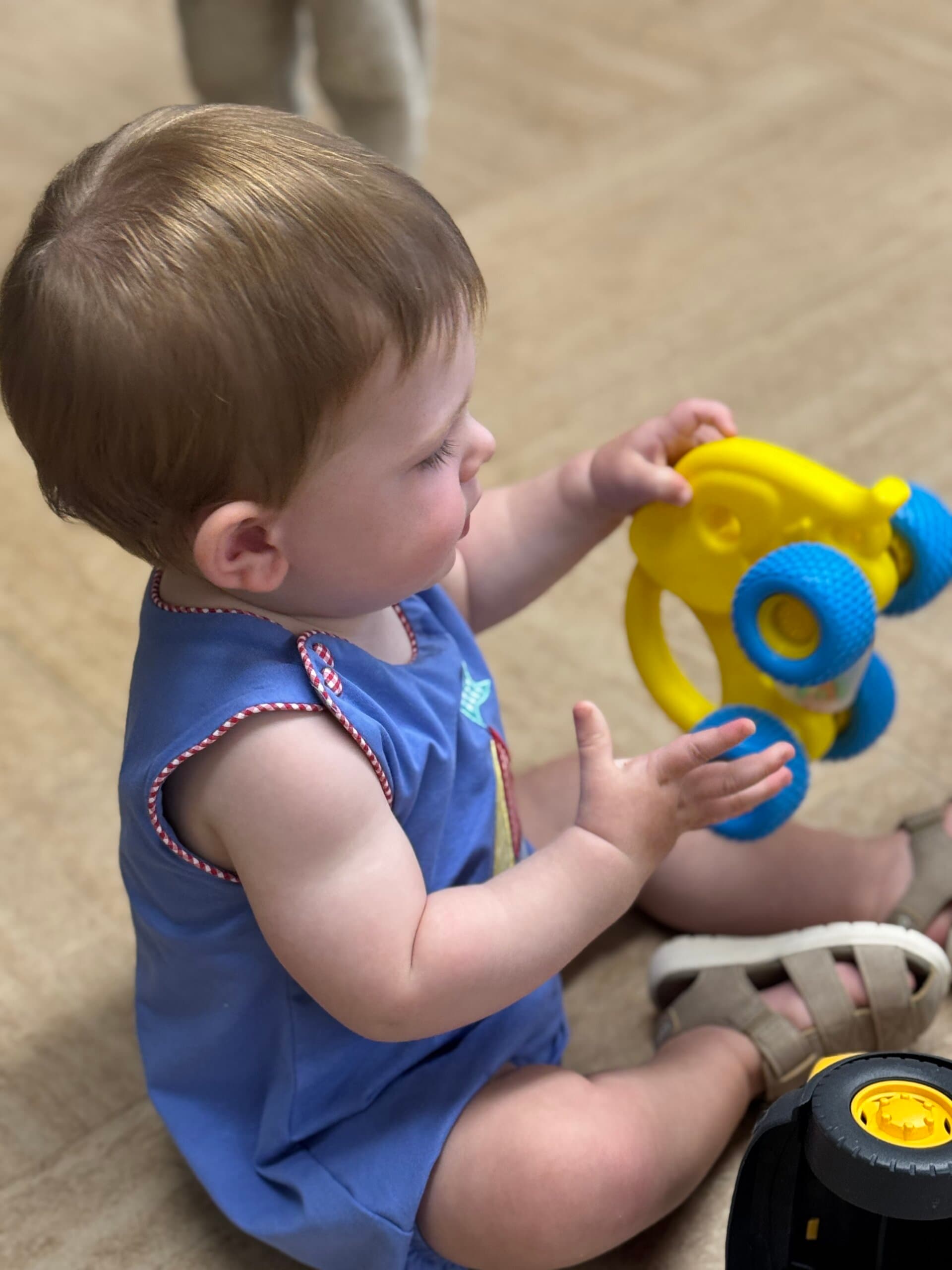 Toddler exploring a colorful toy during playtime at Primrose School of Braselton.