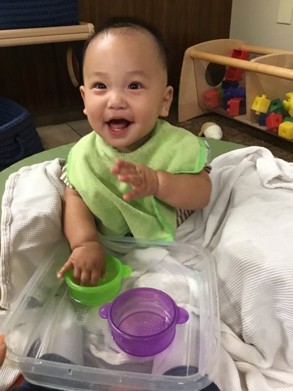 Infant Exploring sensory bin with water
